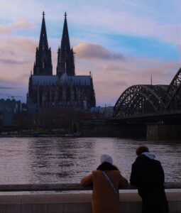 zwei Menschen in Köln mit Blick auf den Rhein und den Kölner Dom